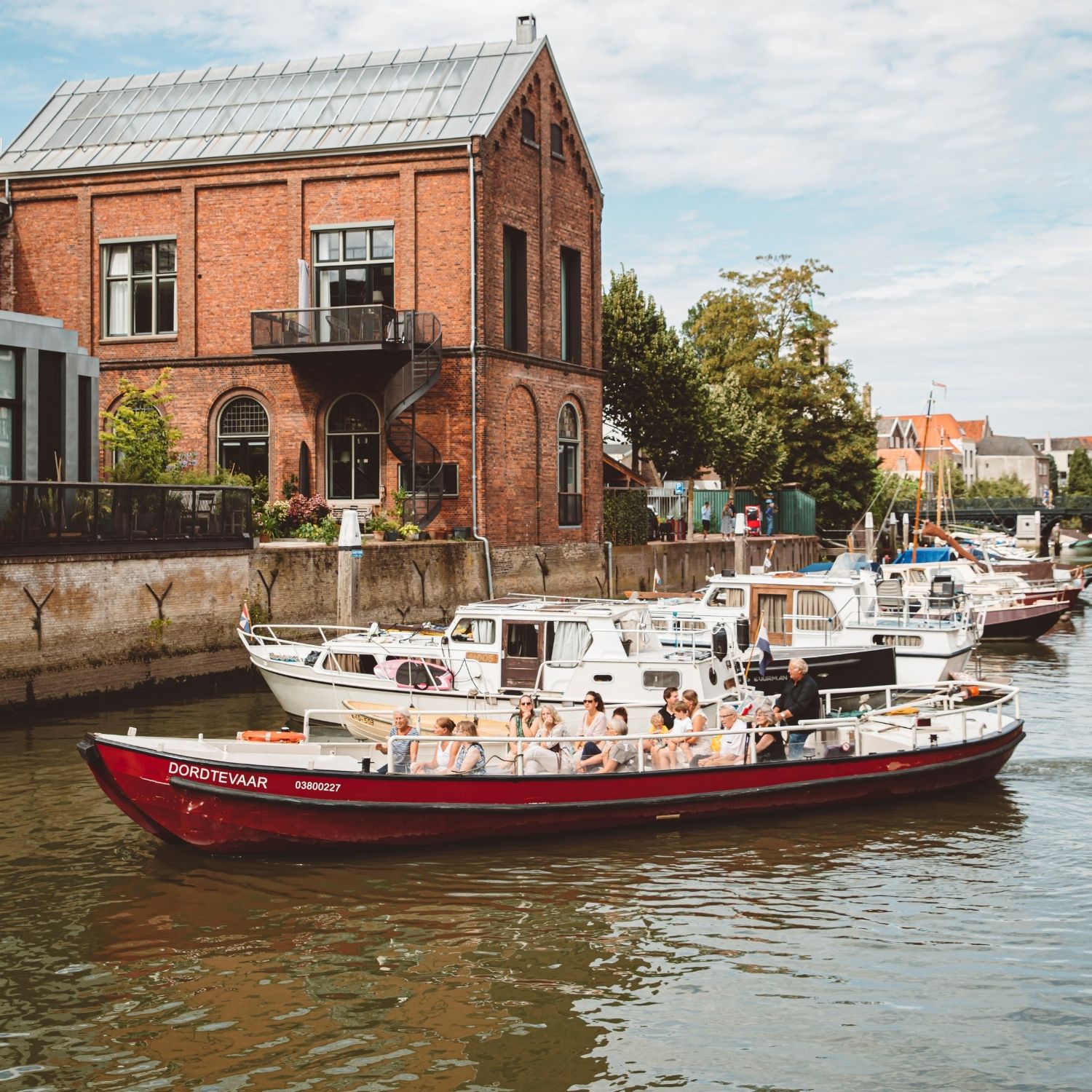 Rode Rondvaartboot Met Passagiers Op Een Gracht Voor Een Rood Bakstenen Pand Met Boten Aan De Kade