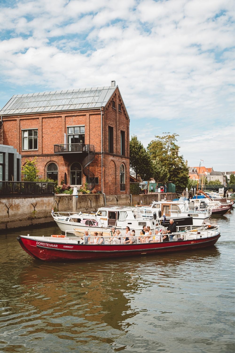 Rode Rondvaartboot Met Passagiers Op Een Gracht Voor Een Rood Bakstenen Pand Met Boten Aan De Kade