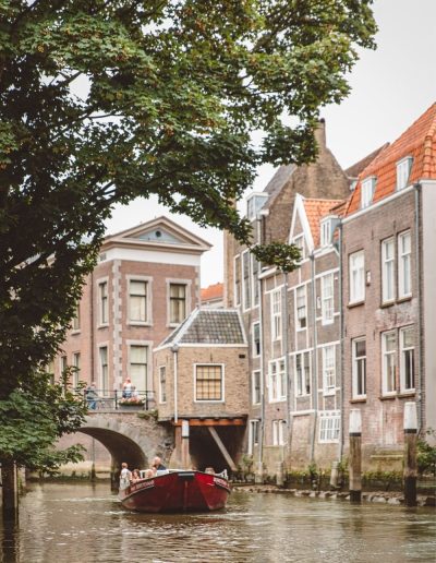 Rode Rondvaartboot Op Een Gracht Langs Historische Grachtenpanden Met Een Stenen Brug